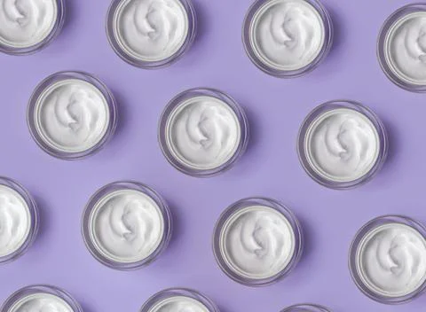 Pattern of White cream jar on violet blue background close-up. Beauty cosmetics Stock Photos