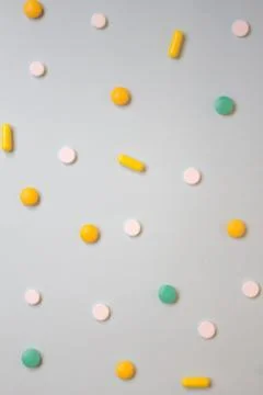 Pattern of white, green and orange pills and tablets on a blue background. As Stock Photos