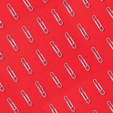 Pattern of white paper clips on red background. Back to school. Office, business Stock Photos