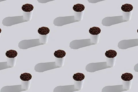 Pattern white paper disposable cups with coffee beans on white background Stock Photos
