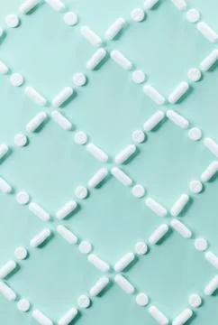 Pattern of white pills and tablets on a green background. Foto stock