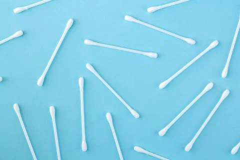 Pattern of white plastic cotton swabs or sticks top view on blue background Stock Photos