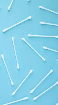 Pattern of white plastic cotton swabs top view on blue background Stock Photos
