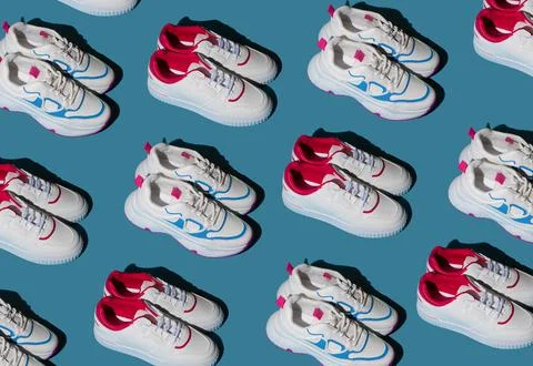 Pattern of white sneakers on a blue background. New sports shoes. Pair of casual Foto stock