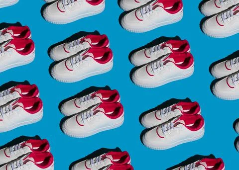 Pattern of white sneakers on a blue background. New sports shoes. Pair of casual Foto stock