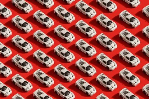 Pattern of white toy car model Ferrari on red background Stock Photos