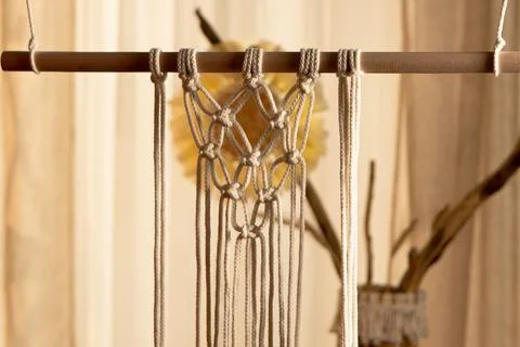 Pattern of whites macrame threads on a stick for decoration or home decor. Home Stock Photos