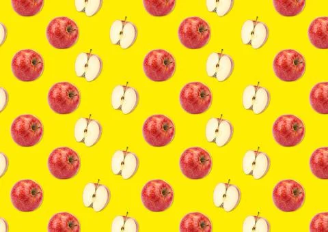 Pattern of whole and halved apples on yellow background Stock Photos
