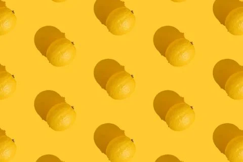 Pattern of a whole lemon on a yellow background with a hard shadow. The concept Stock Photos