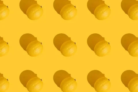 Pattern of a whole lemon on a yellow background with a hard shadow. The concept Stock Photos