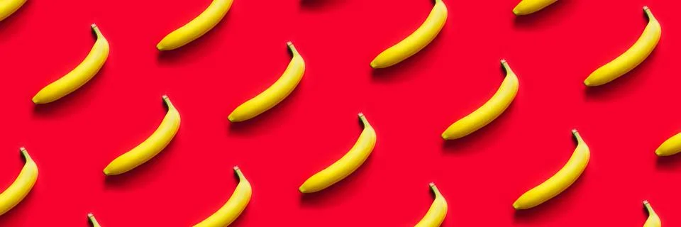 Pattern of yellow bananas on a red background. Stock Photos