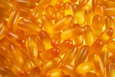 Pattern of yellow gelatin capsules for background. omega viramins, close-up, Stock Photos