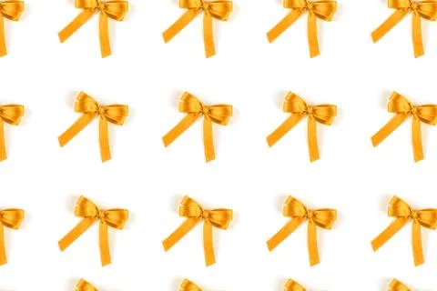 Pattern of yellow silk gift bows isolated on white. Stock Photos