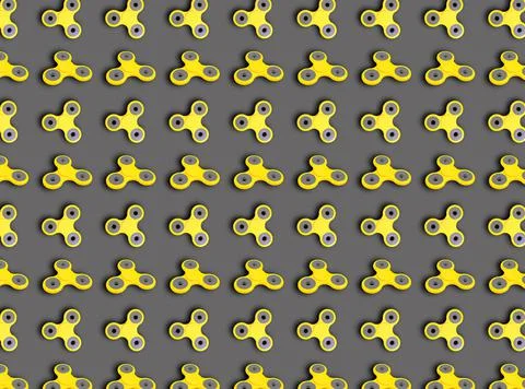 A pattern of yellow spinners on a gray background. Stock Photos