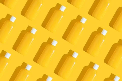 Pattern of yellow tubes of sunscreen on bright yellow background with hard Stock Photos