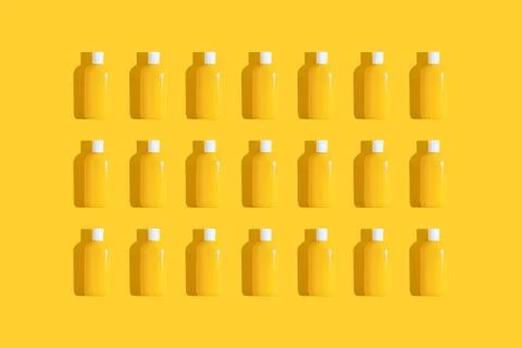 Pattern of yellow tubes of sunscreen on bright yellow background with hard Stock Photos