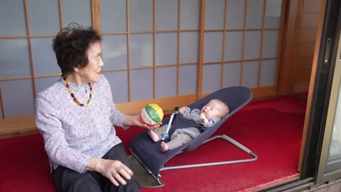 Patterned Ball Shown to Infant Reclining in Bouncer Stockbeeldmateriaal 344859503