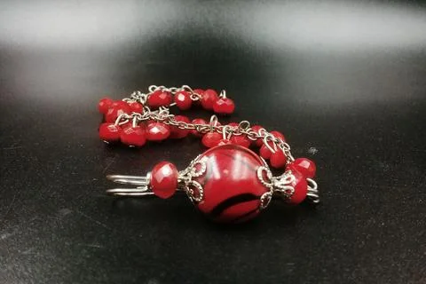 Patterned beaded bracelet, red color, associated with silver color metal Stock Photos