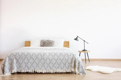 Patterned blanket on king-size bed Stock Photos