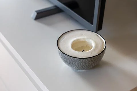 Patterned bowl candle beside flat screen TV in Malbork apartment Stock Photos