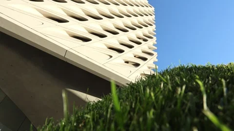 Patterned Building Exterior Beyond Grassy Hill Stock Footage 335343674