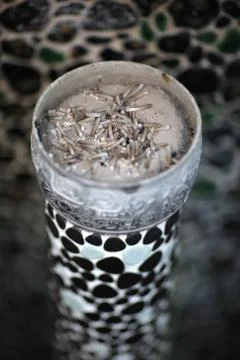 Patterned ceramic ashtray with sand and cigarette butts Stock Photos