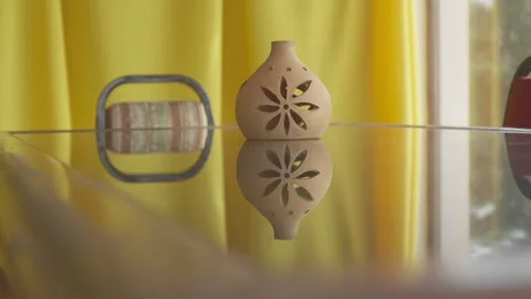 A patterned ceramic vase and its reflection on a polished glass surface Stock Footage 342859346