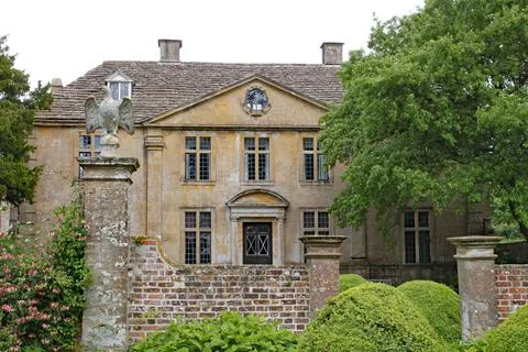 A patterned concrete block walkway between rounded topiary shrubs in an Engli Stock Photos