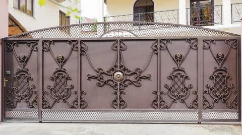 Patterned expensive iron fence of a private house. Villa entrance. Production of Stockfoto's