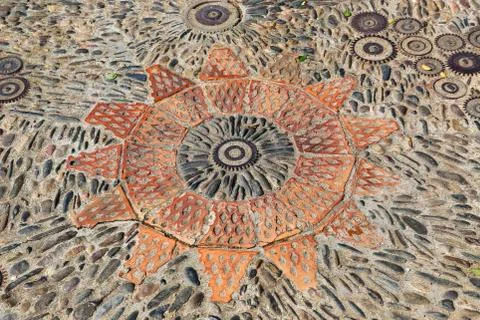 Patterned floor with pattern from pebbles bricks and gears Foto stock