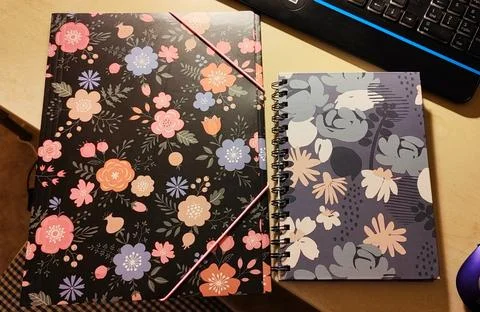 A patterned folder and notebook on a desk Stock Photos