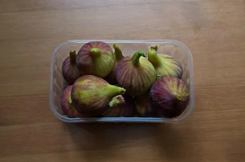 Patterned green and red whole ripe figs in commercial packaging Stock Photos