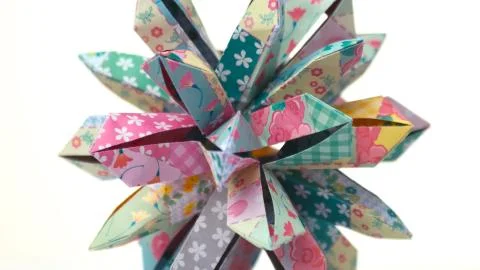 Patterned origami flower on white background. Stock Photos
