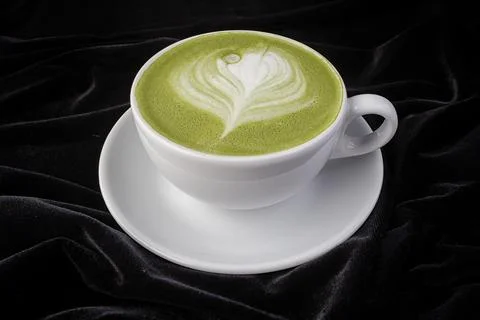 Patterned pistachio cappuccino in a white cup Stock Photos