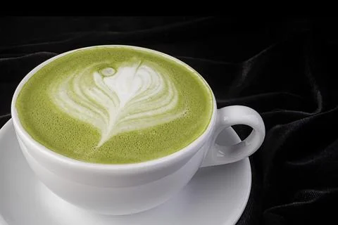 Patterned pistachio cappuccino in a white cup Stock Photos