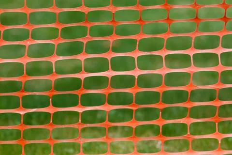 Patterned plastic safety netting with green and orange color blocks Stock Photos