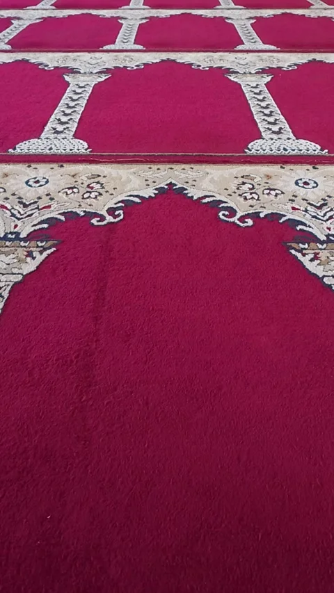 Patterned red prayer carpet arranged across mosque floor Stock-Footage 342577424