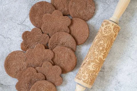 Patterned rolling pin next to homemade cookies from above Stock Photos