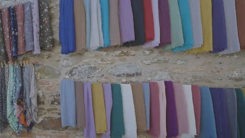 Patterned shawls and fabrics on market in island village Stock Footage 252503722