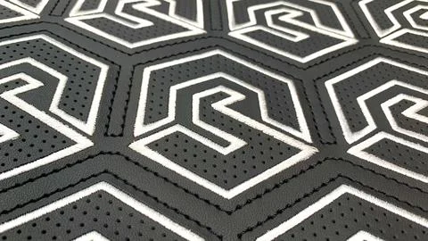 Patterned stitching, embroidery and perforations on black leather Stock Photos
