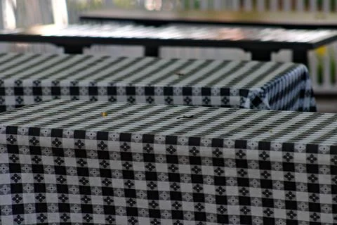 Patterned tablecloths cover empty outdoor dining tables in Long Beach. Stock Photos