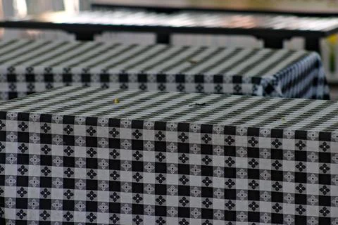 Patterned tablecloths cover empty outdoor dining tables in Long Beach. Stock Photos