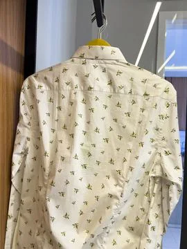 Patterned white shirt on the wardrobe hanger Stock Photos