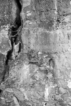 Patterns and textures of a rock wall with holes, black and white Stock Photos