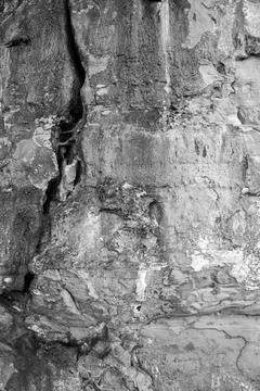 Patterns and textures of a rock wall with holes, black and white Stock Photos