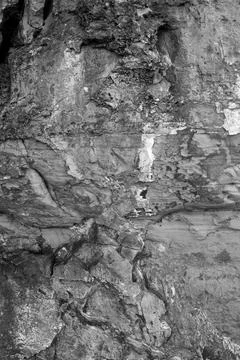Patterns and textures of a rock wall with holes, black and white Stock Photos