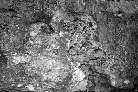 Patterns and textures of a rock wall with holes, black and white Stock Photos