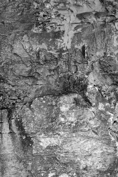 Patterns and textures of a rock wall with holes, black and white Stock Photos