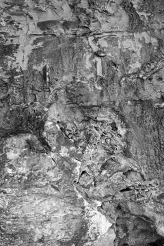 Patterns and textures of a rock wall with holes, black and white Stock Photos