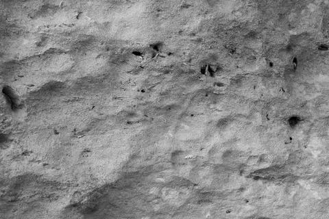 Patterns and textures of a rock wall with holes, black and white Stock Photos